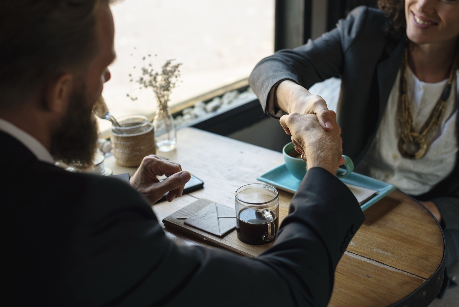 poignée de main entre deux personnes après un accord financier, dans un cadre professionnel