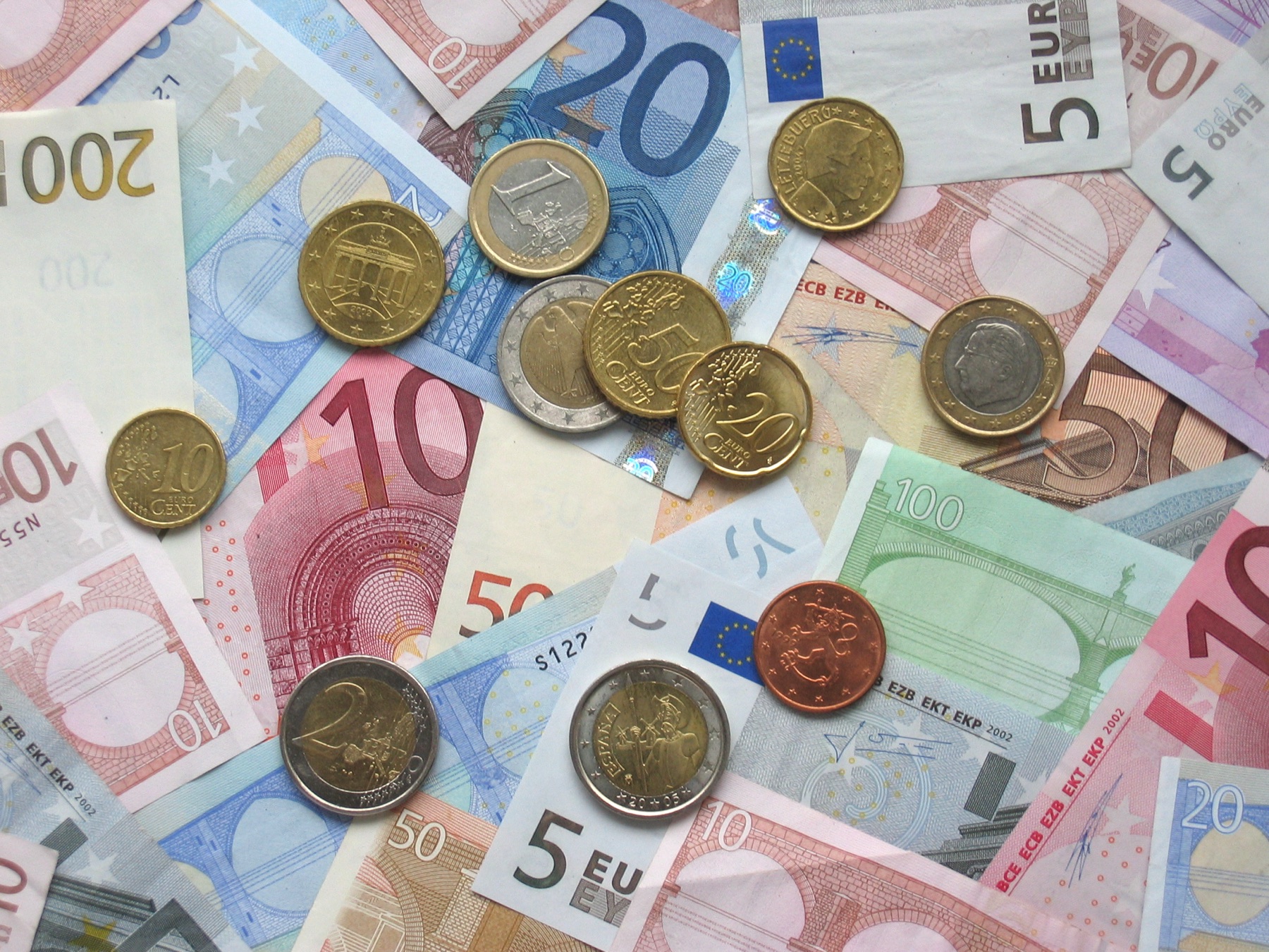 pièces et billets en euros disposés sur une table, illustrant le coût total d'un crédit