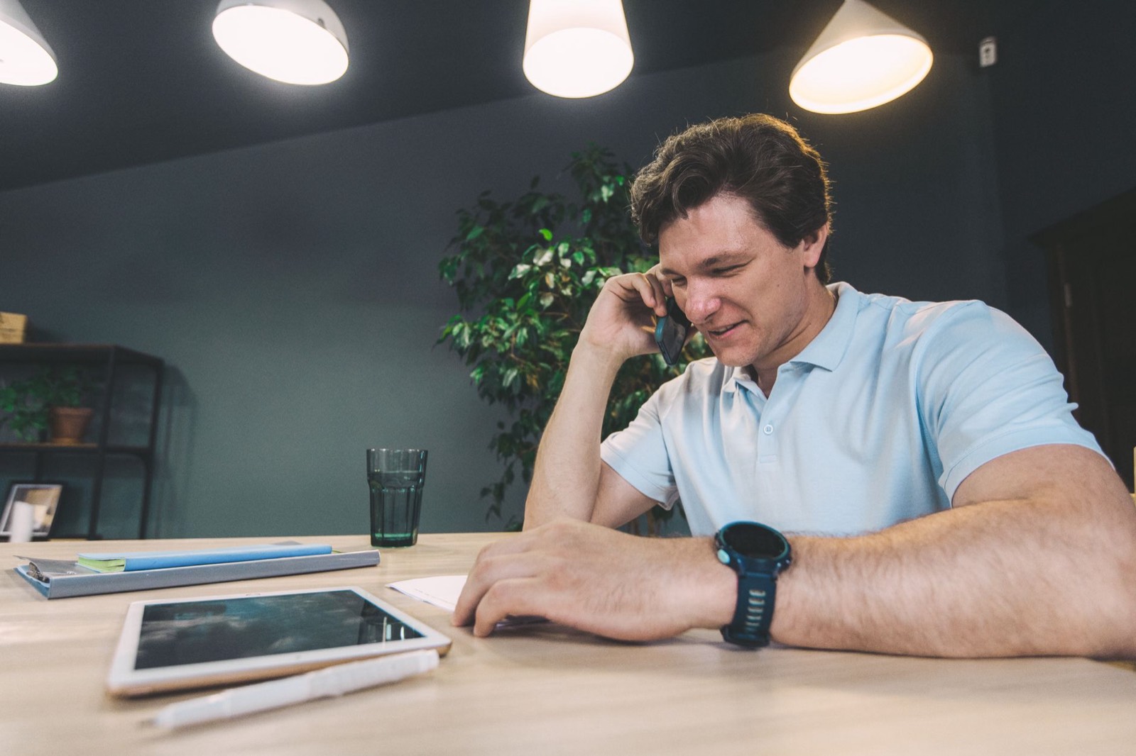Artisan électricien remplissant des documents sur une tablette à l'arrière de son utilitaire