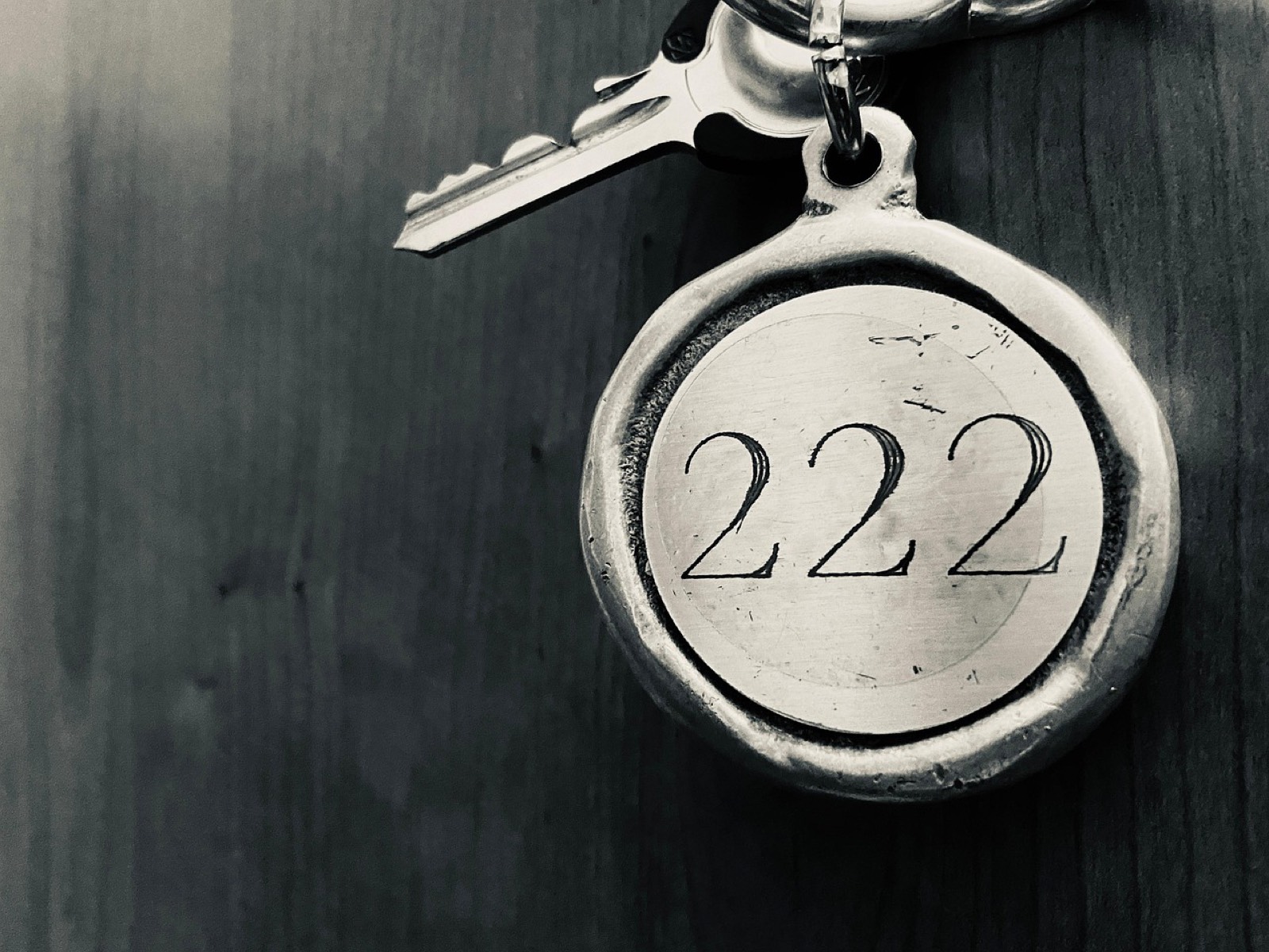 Clés de chambre d'hôtel posées sur un comptoir de réception lors d'une réservation de séjour